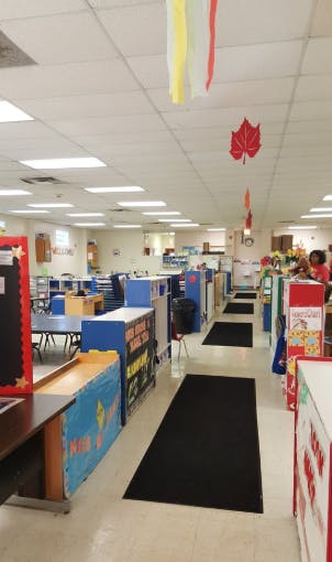 Classroom with tables, chairs, and decorations hanging from the ceiling