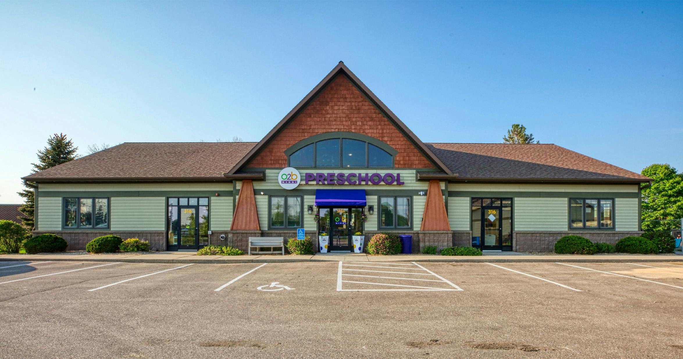 Exterior of a preschool building with 'O2B Kids! Preschool' above the entrance