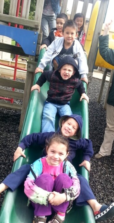 Multiple children on a playground slide