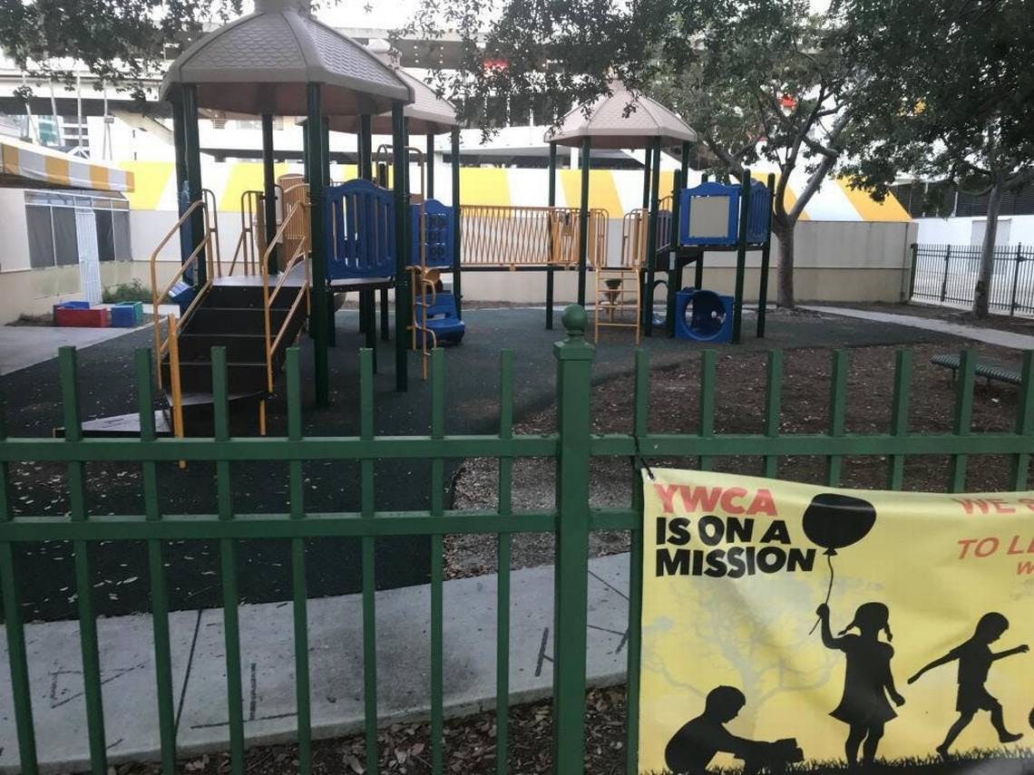 Playground with climbing structures and a banner on a fence