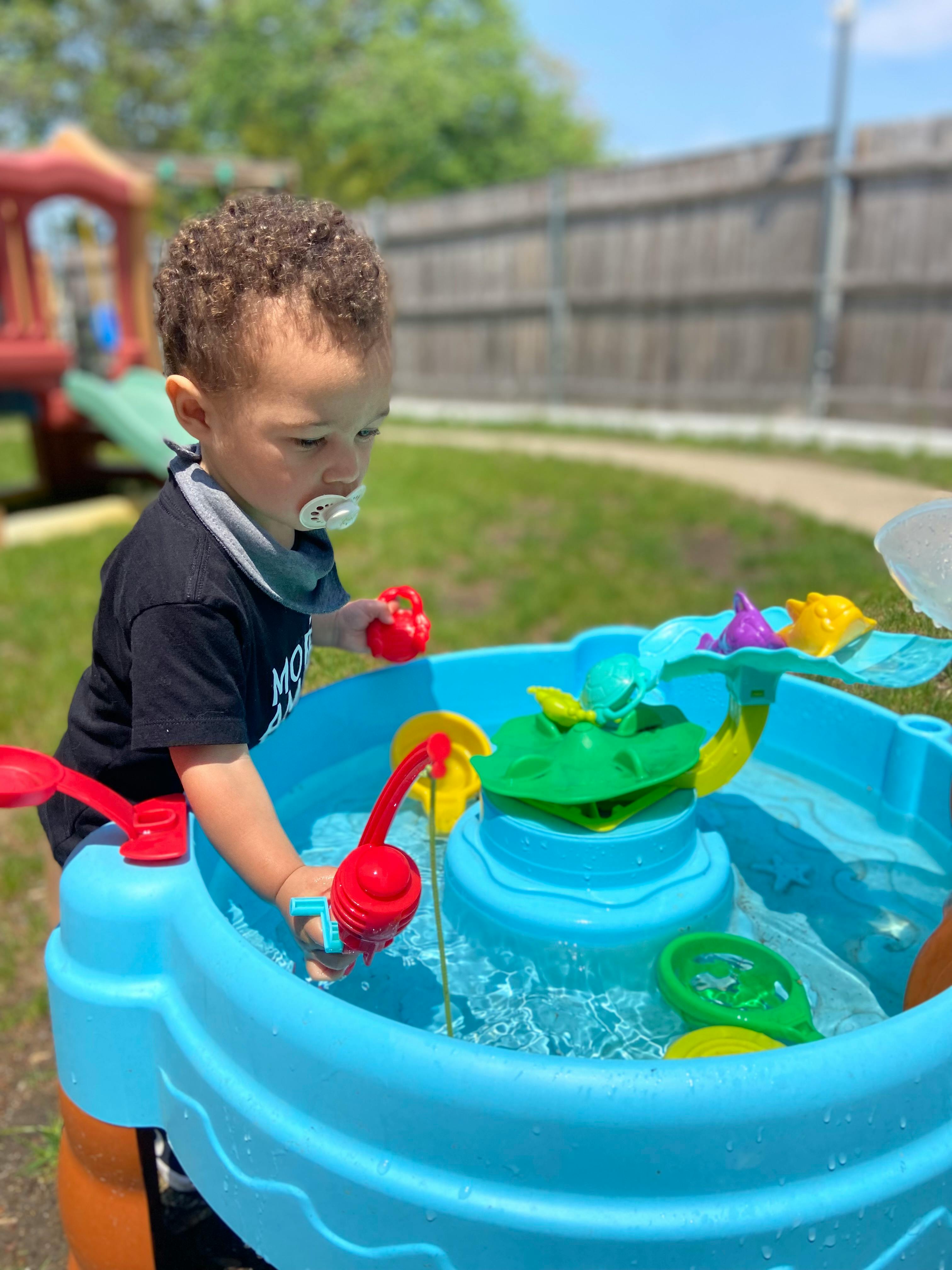 Child playing with a water table outdoors