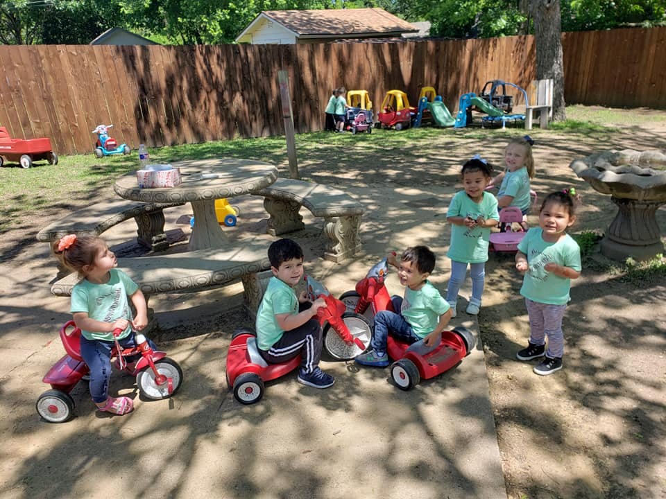 Children playing with ride-on toys outdoors