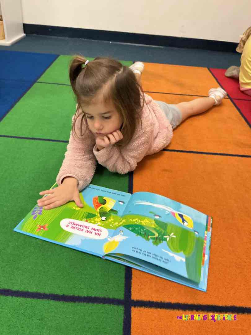 Child lying on floor reading a book