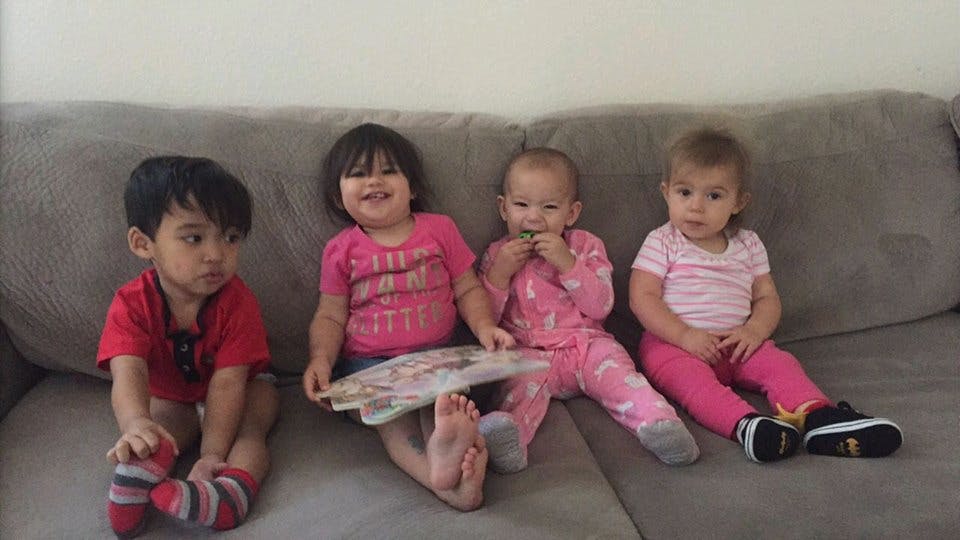 Four young children sitting on a couch