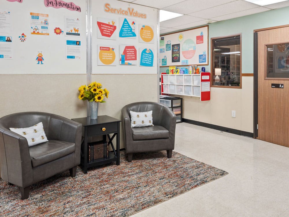 Two armchairs with a side table and sunflowers in a waiting area