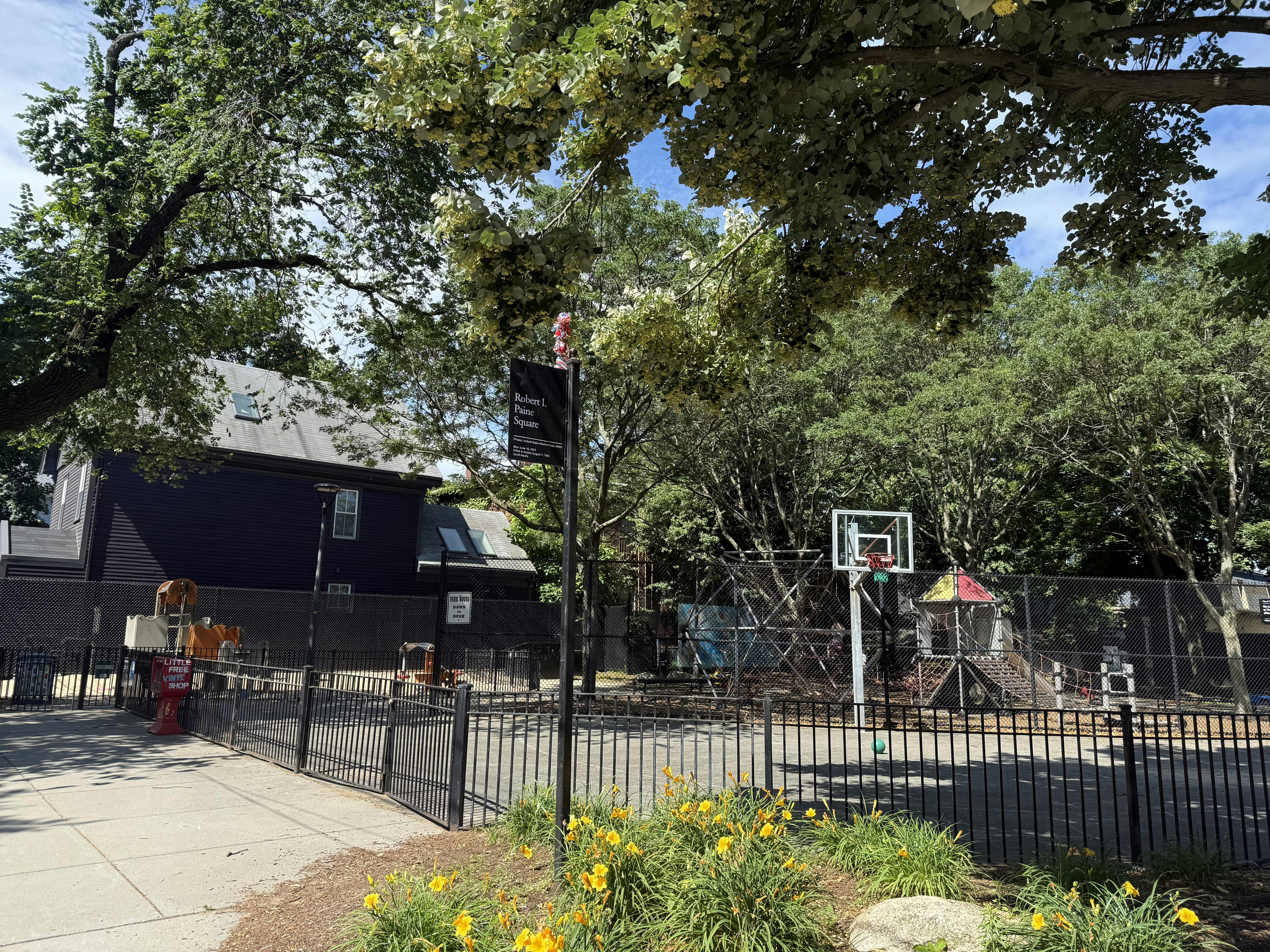 Basketball hoop and playground behind a fence