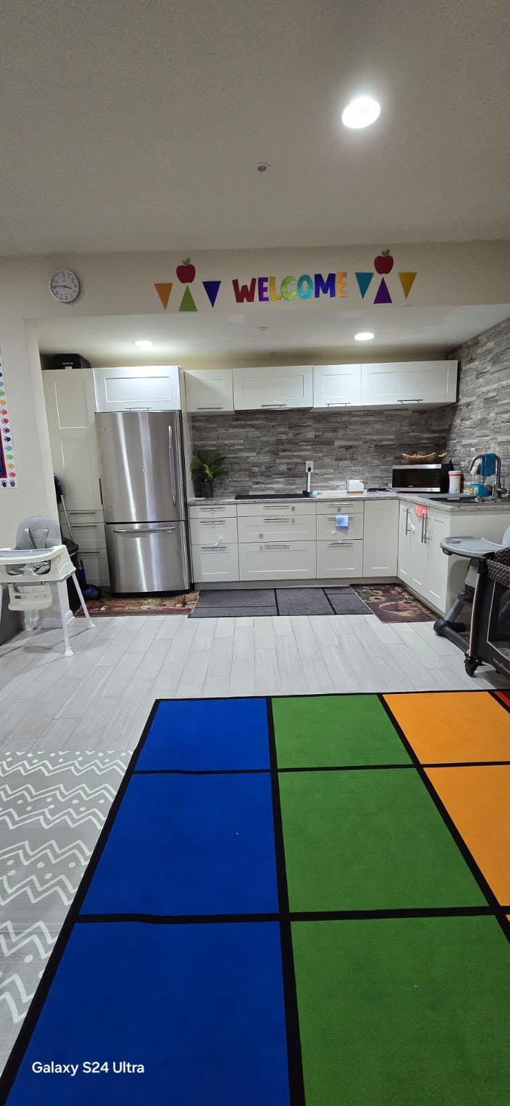 Kitchen with white cabinets, stainless steel appliances, and a Welcome sign