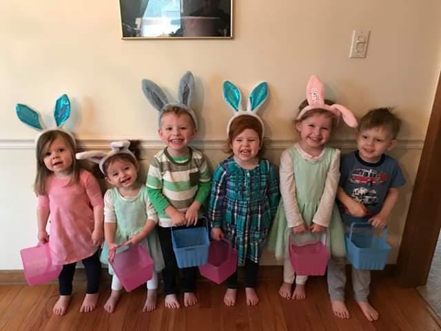 Six children wearing bunny ears and holding baskets