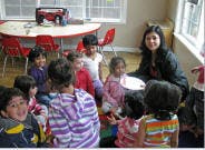 Person with a group of children in a classroom
