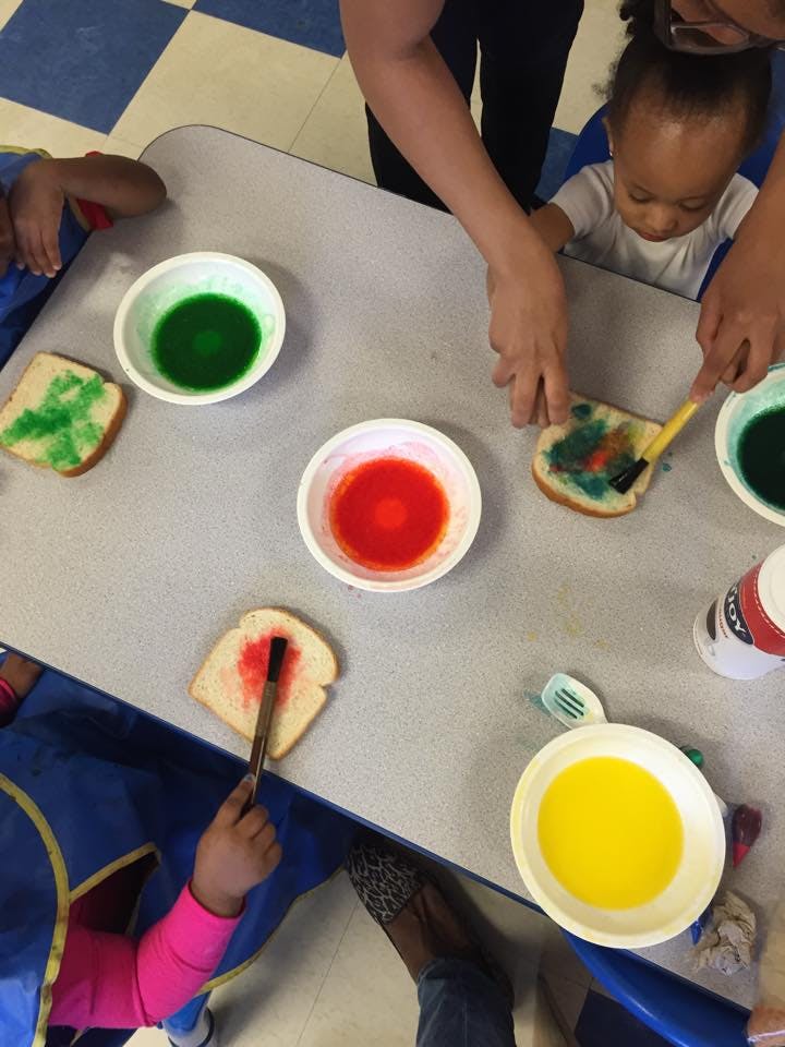 People painting on slices of bread with colorful liquids