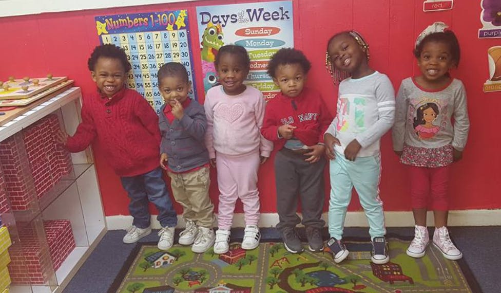 Six children standing in a classroom