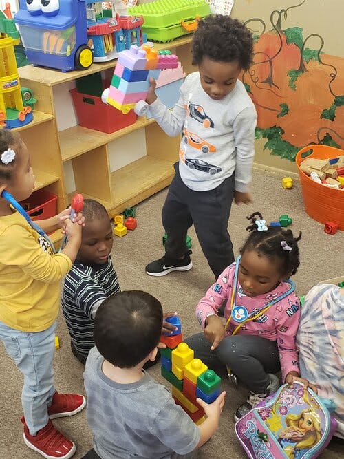 Children playing with building blocks and toys in a classroom