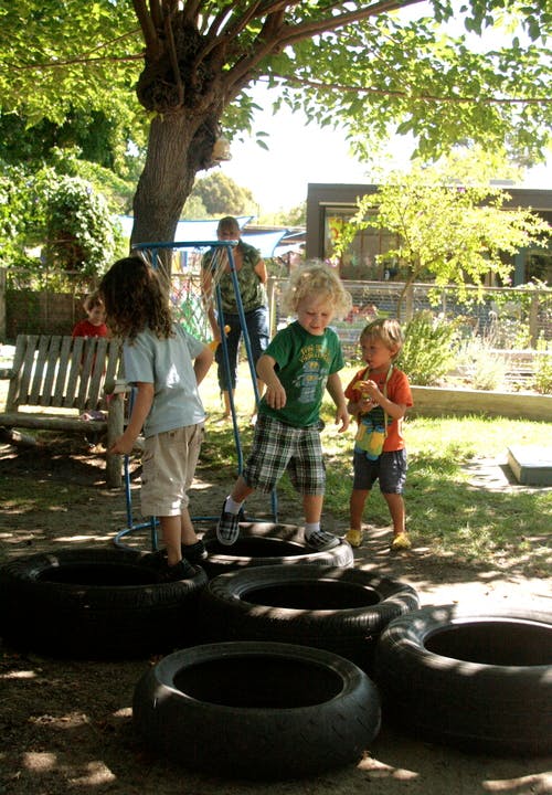 Children playing on tires outdoors