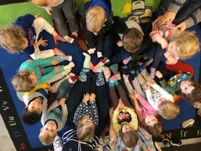 Group of children sitting in a circle on a rug