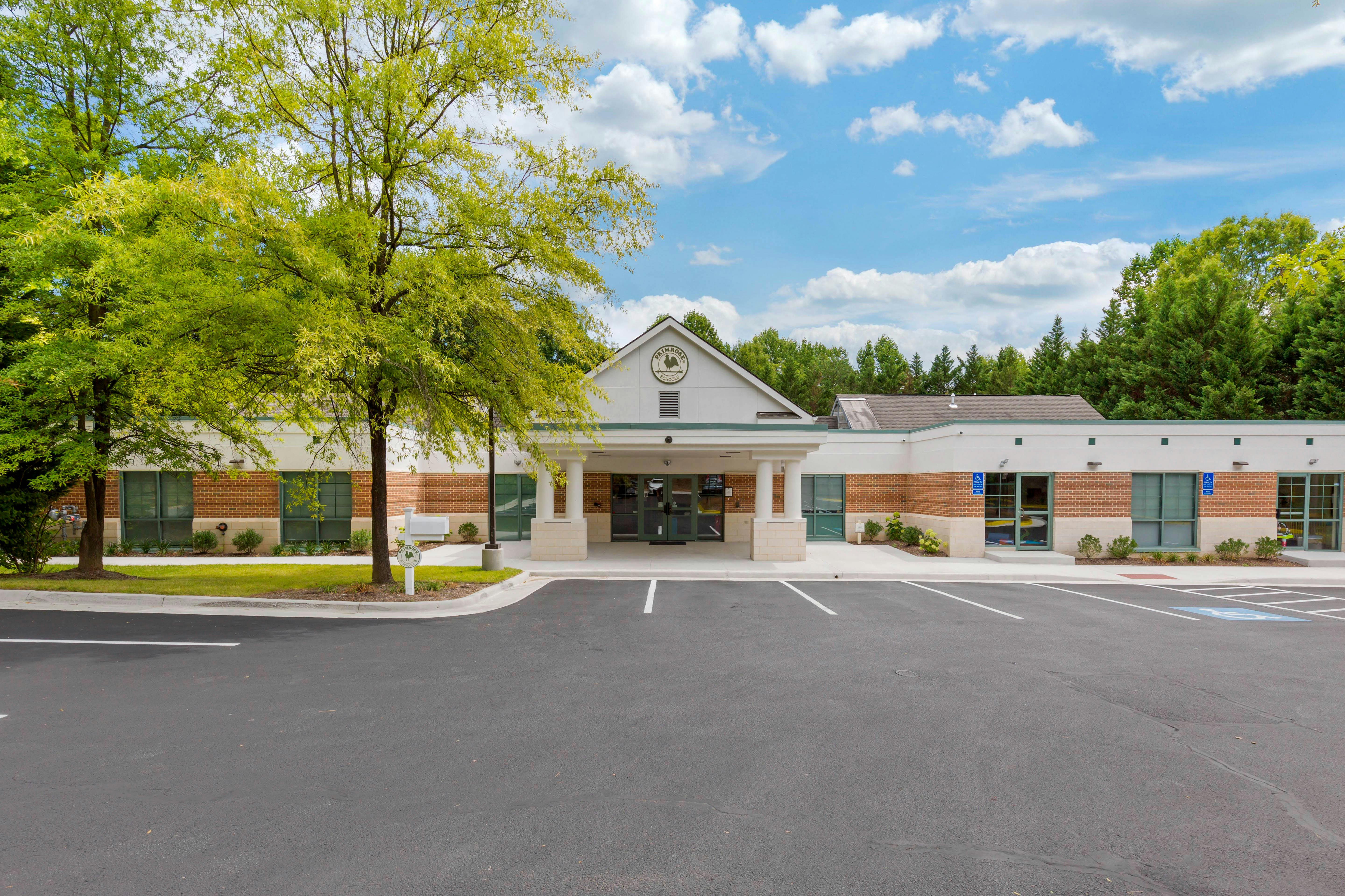 Exterior view of a Primrose Schools building and parking lot under a blue sky