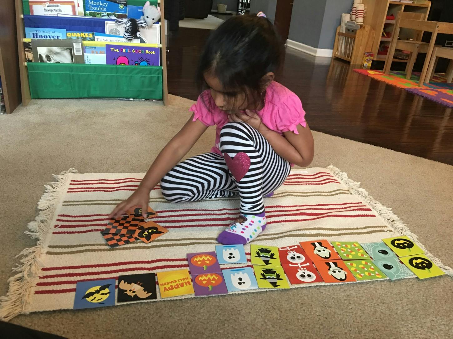 Child playing with cards on a rug
