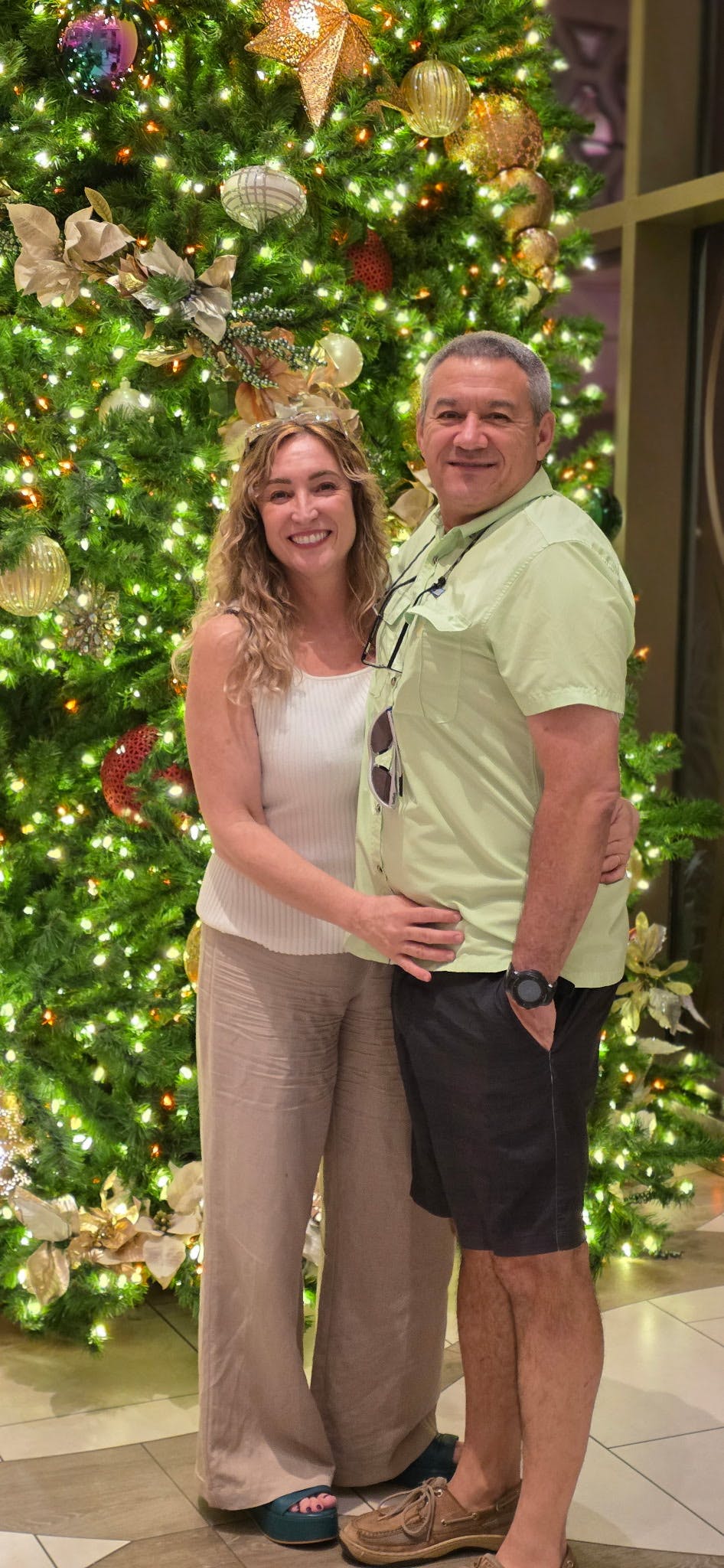Two people standing in front of a decorated Christmas tree