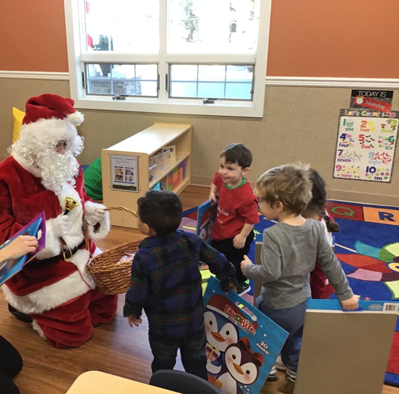 Person dressed as Santa Claus with children in a classroom