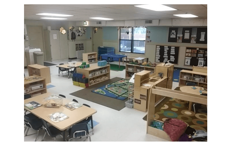 Classroom with small tables, chairs, and learning materials