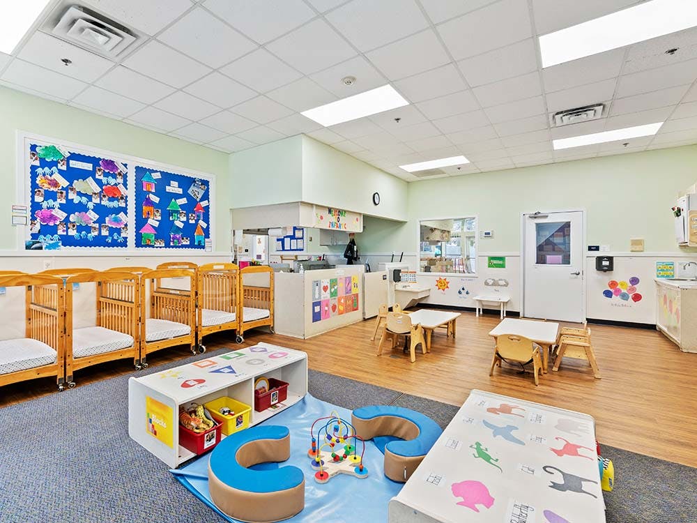 Cribs and play area in an infant classroom