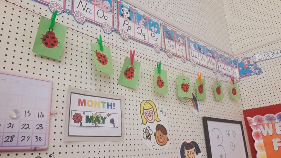 Classroom bulletin board with children's artwork and a calendar