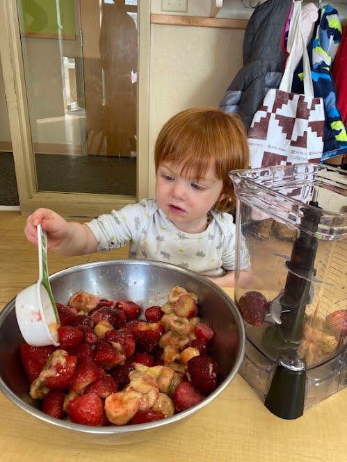 Child putting fruit into a blender
