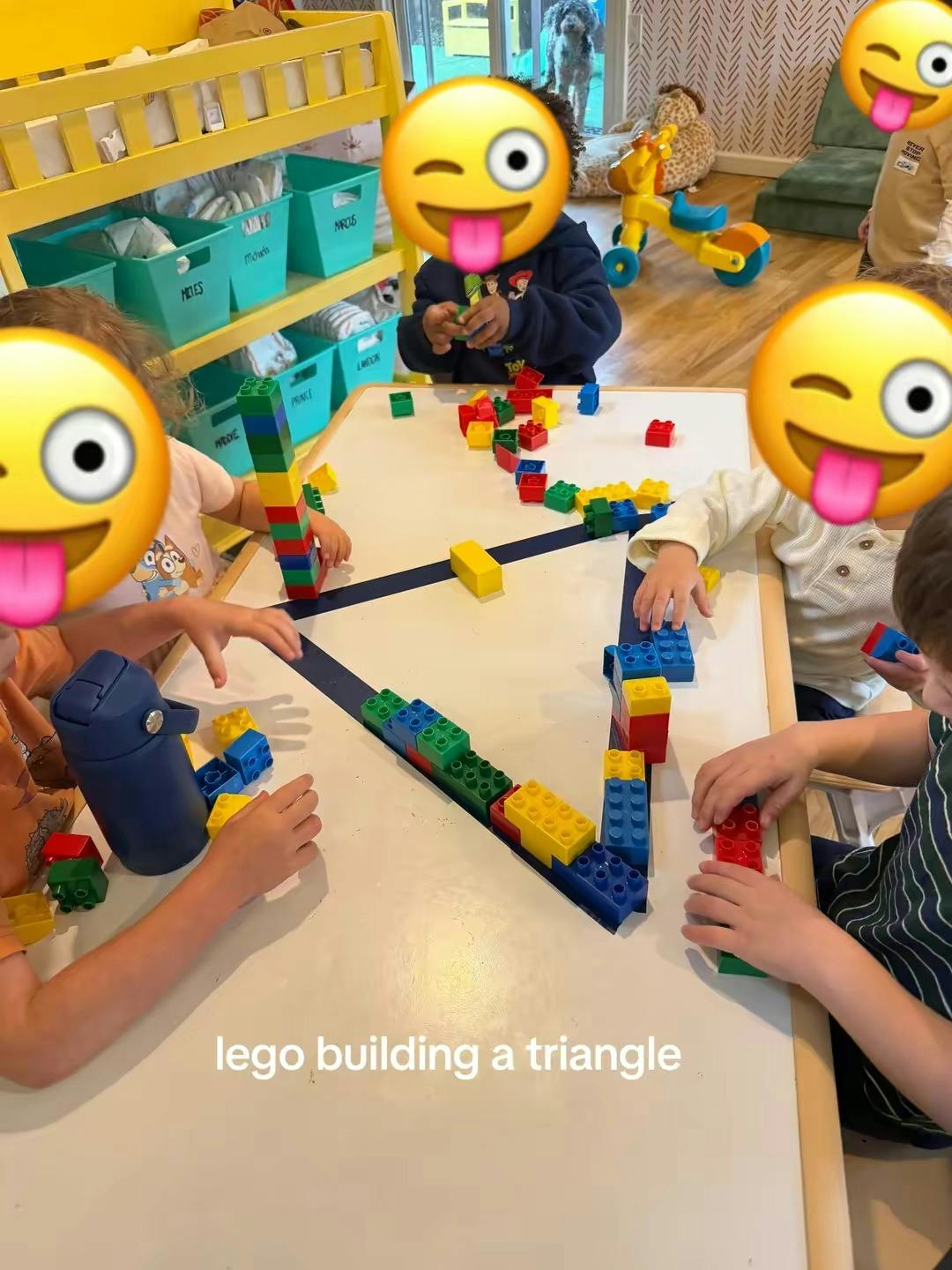 multiple children building with colorful toy blocks on a table