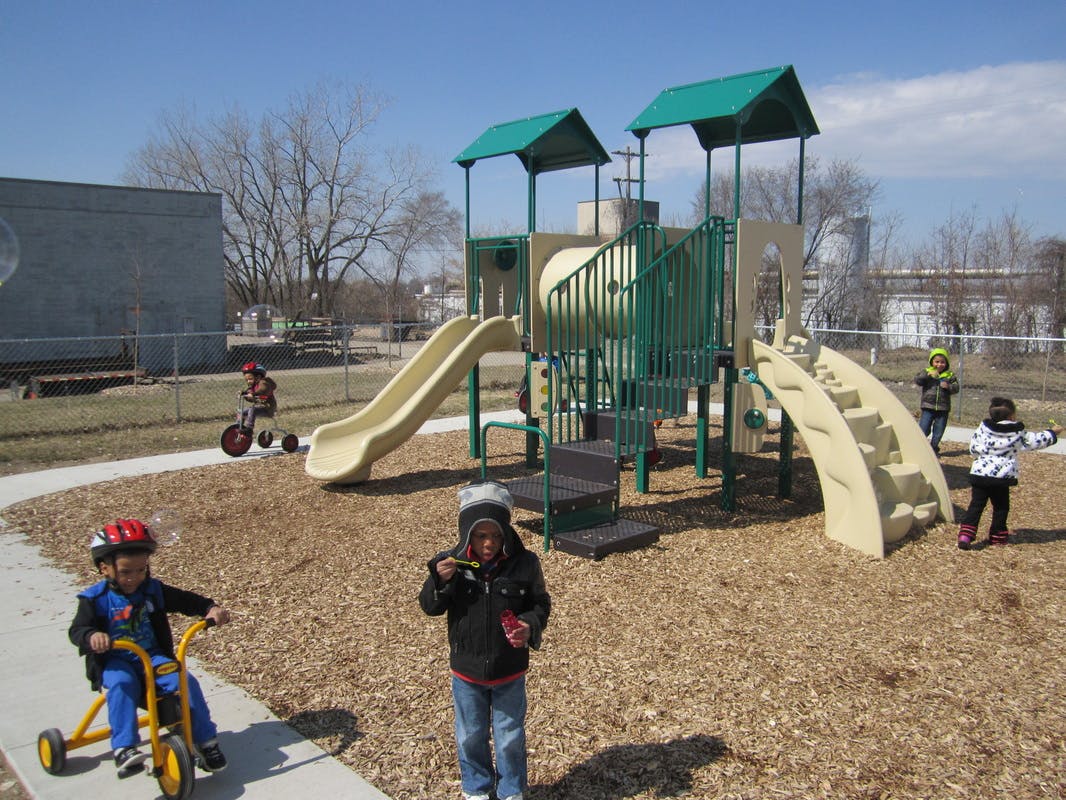 Children playing on a playground with slides and climbing structures