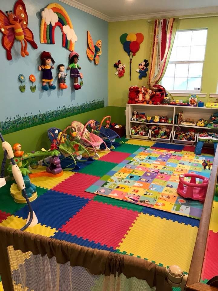 Playroom with colorful floor mats, wall decorations, and shelves of toys