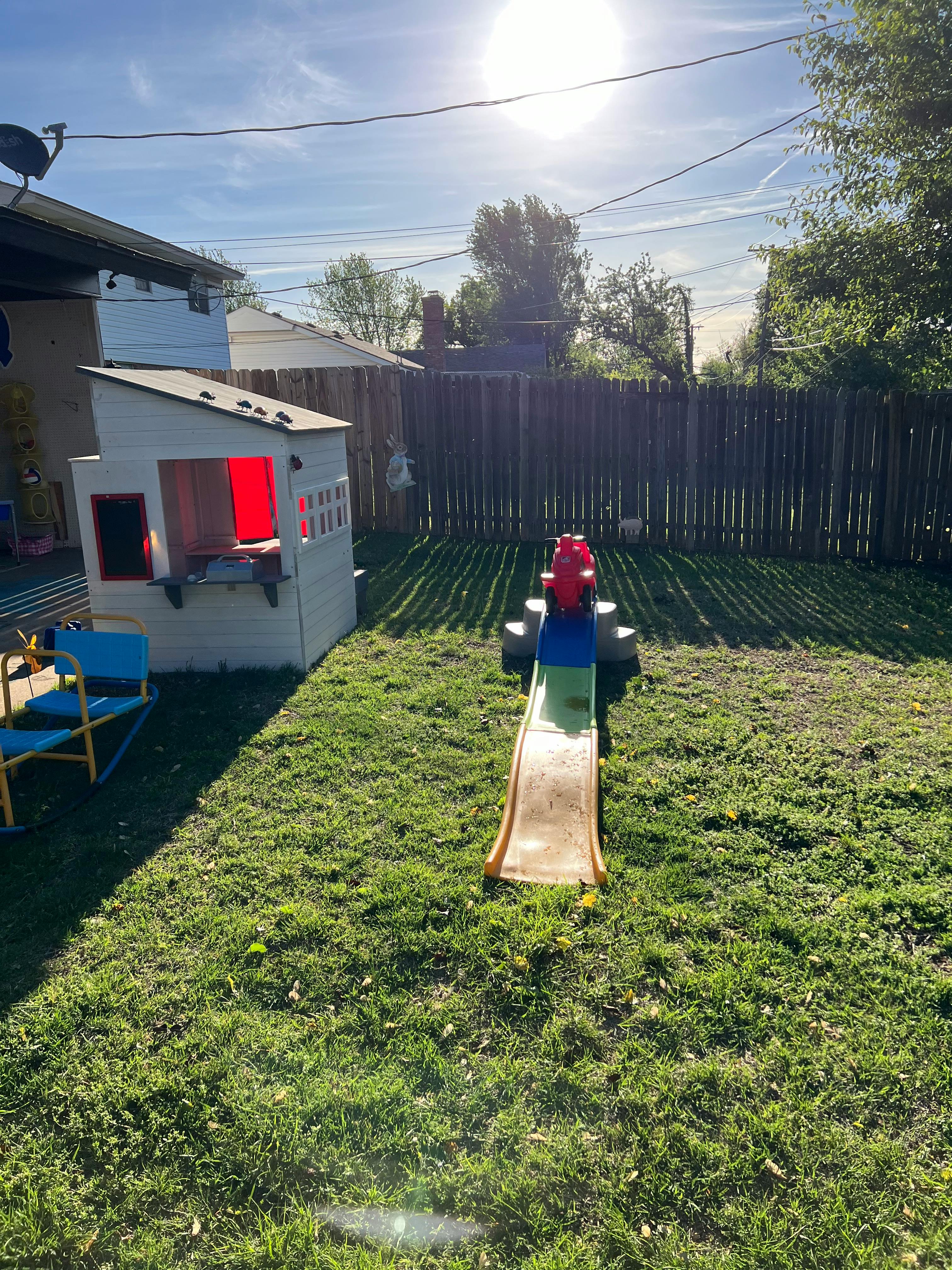 Backyard with a small playhouse and a slide
