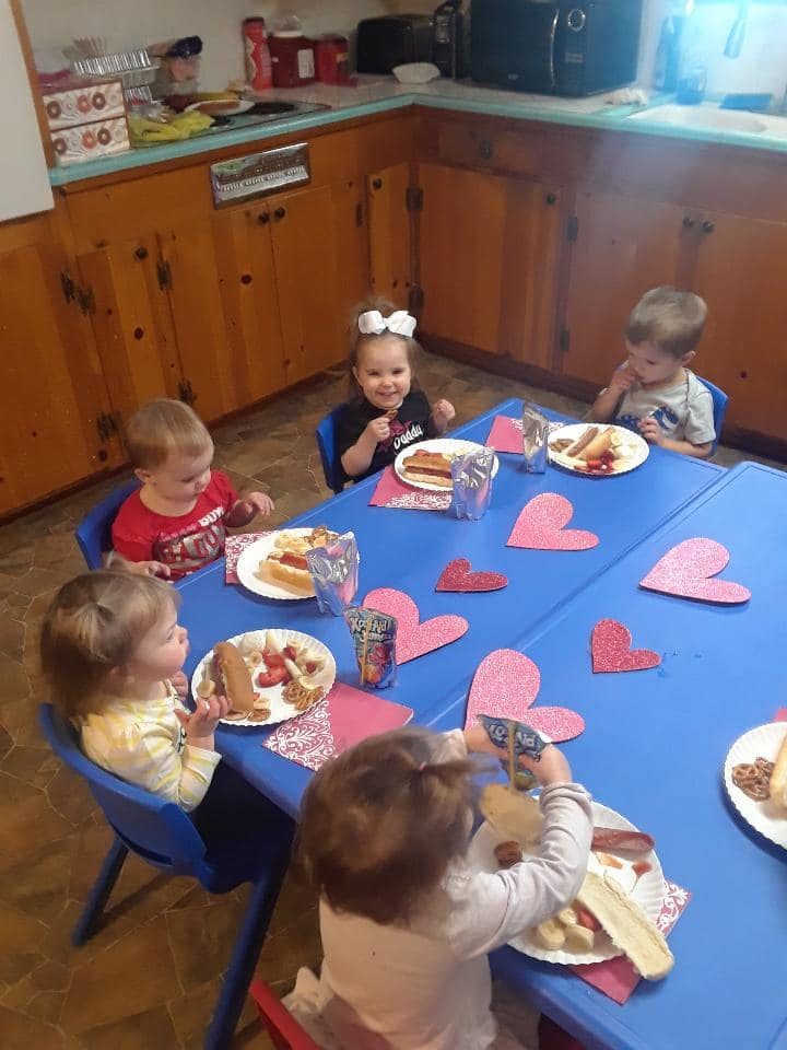 Children eating at a table with heart decorations