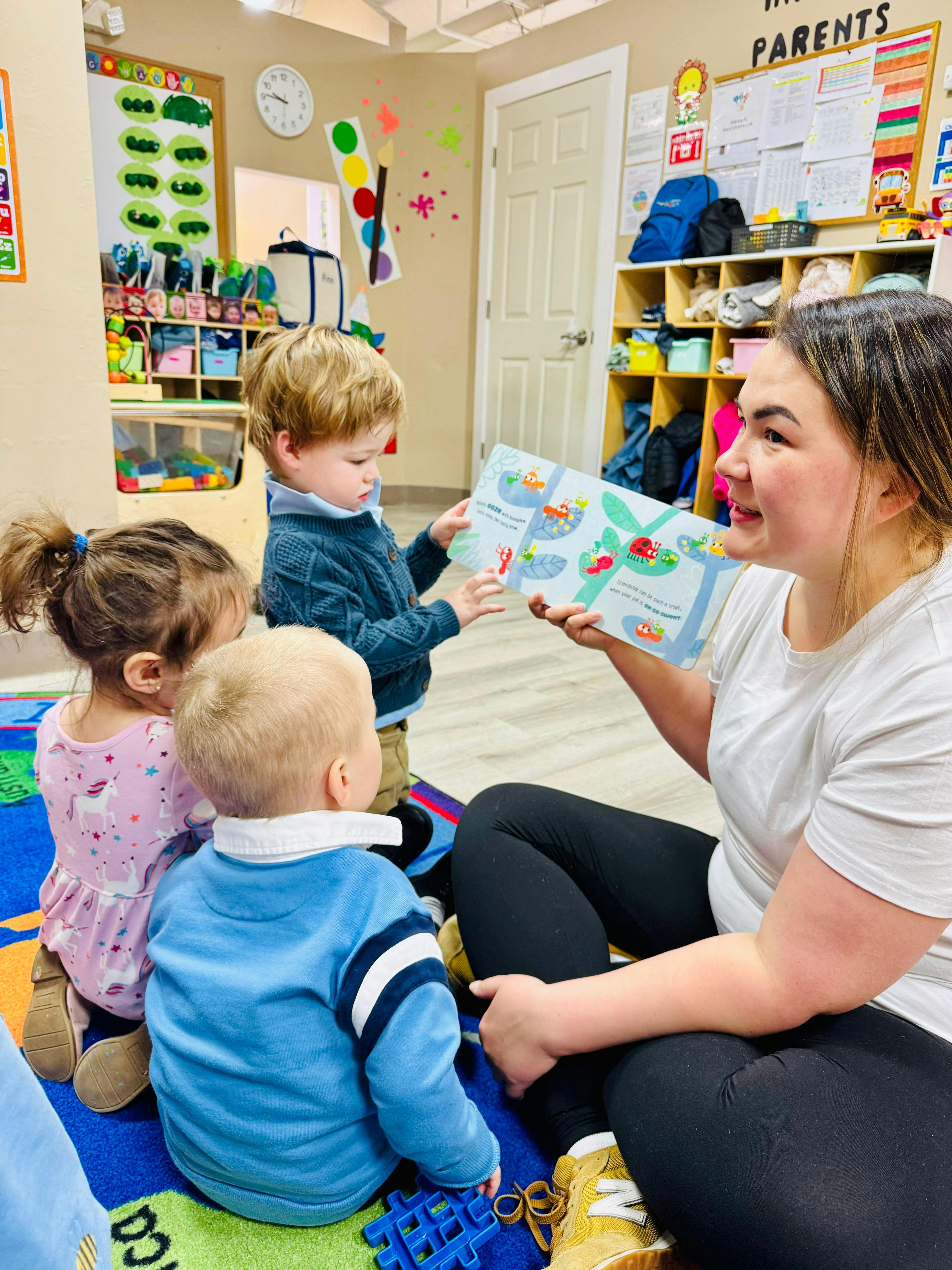 Adult reading a book to children in a classroom