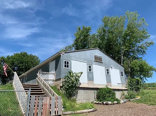 Barn with an American flag and stairs leading up to the entrance