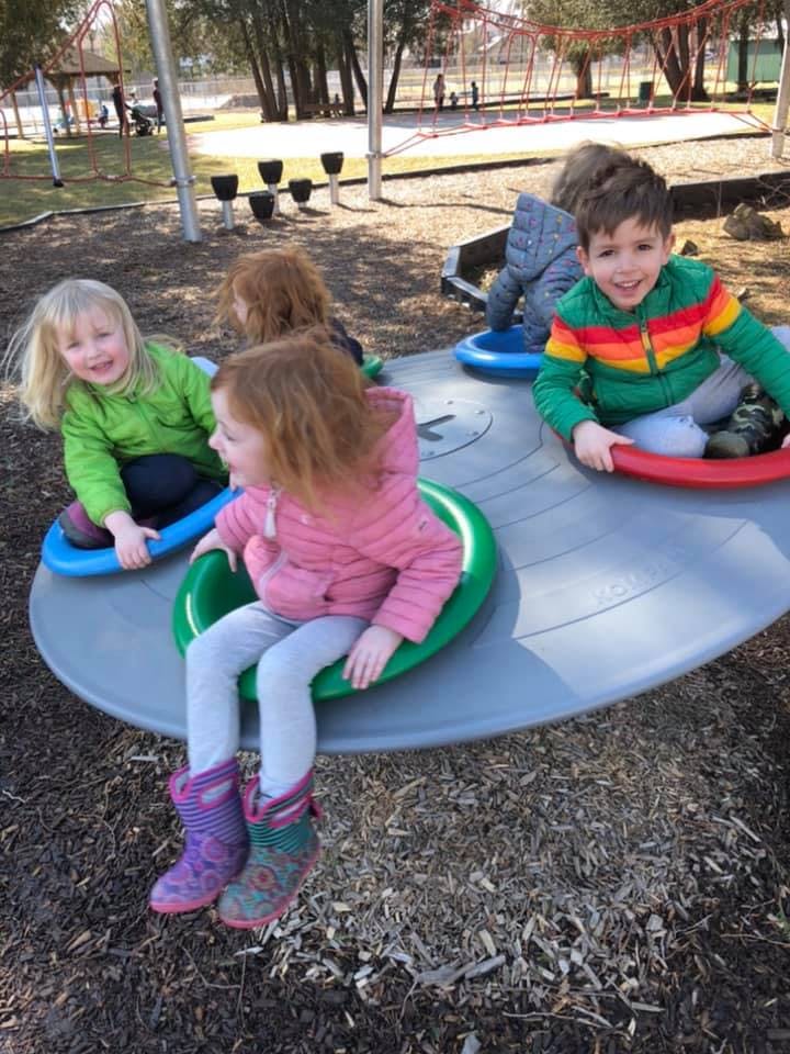 Children playing on a spinning playground ride