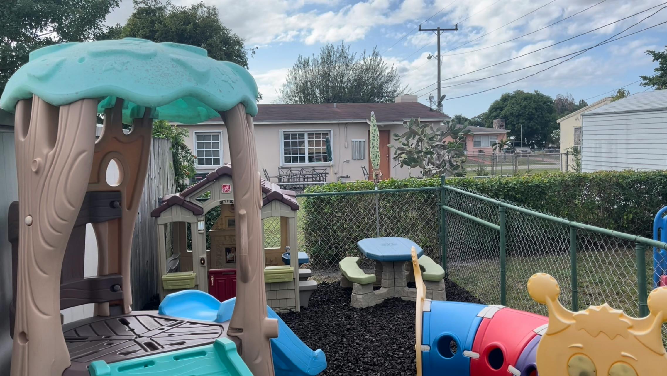 Outdoor playground with play structures and a small picnic table