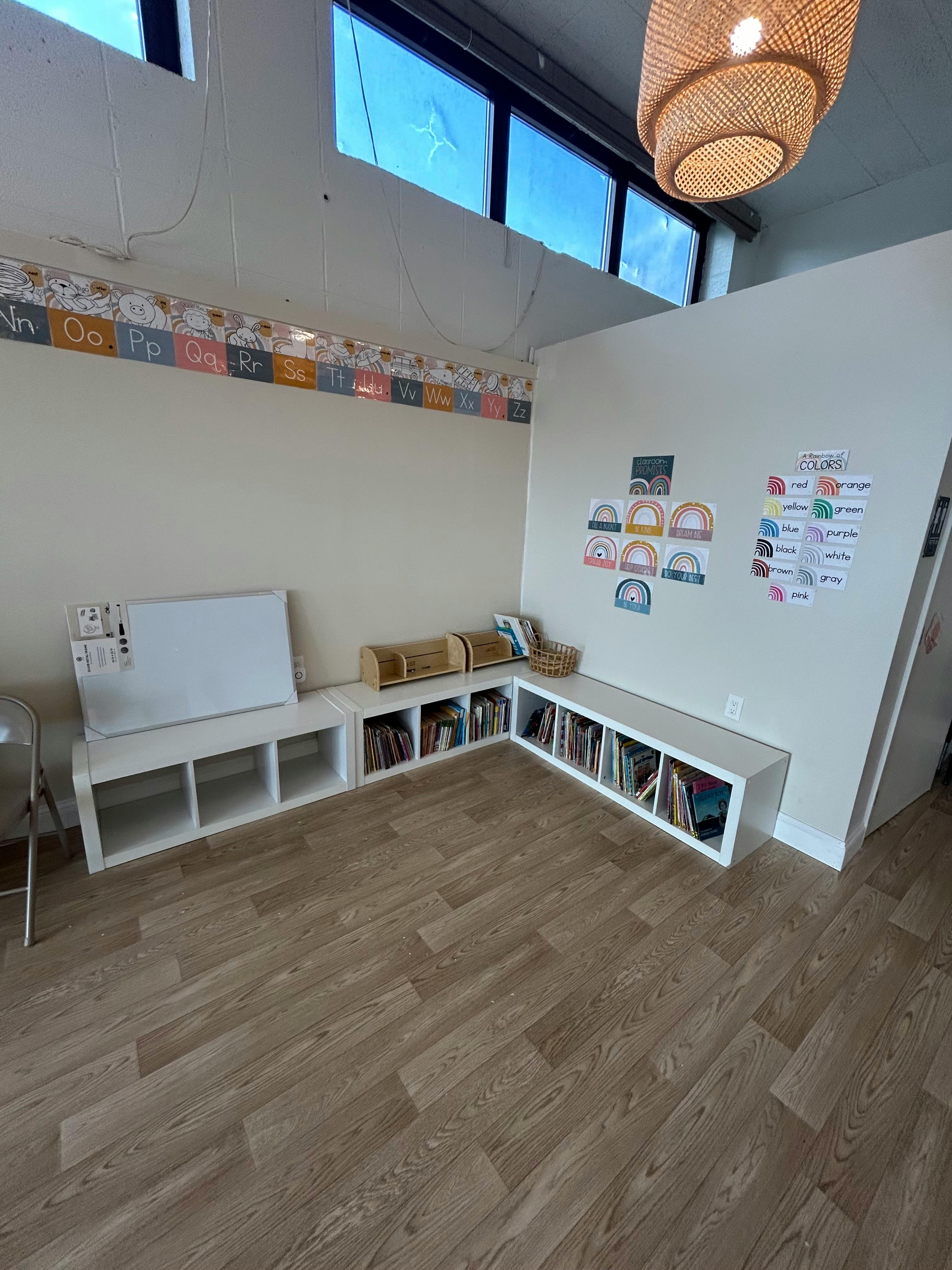 Classroom with white storage cubbies filled with books and a whiteboard
