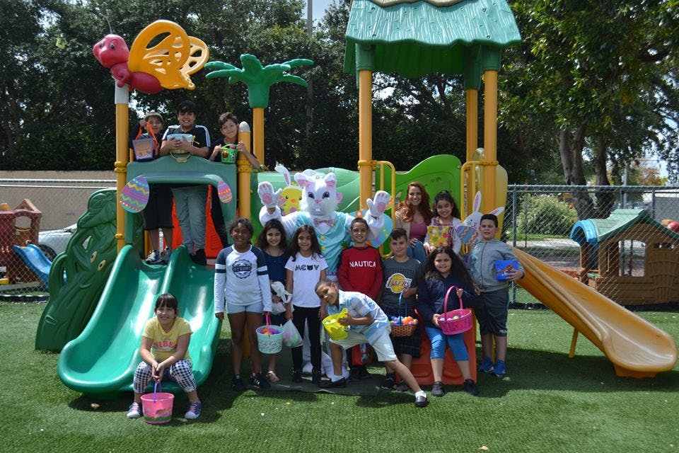 Children and a person in a bunny costume on a playground
