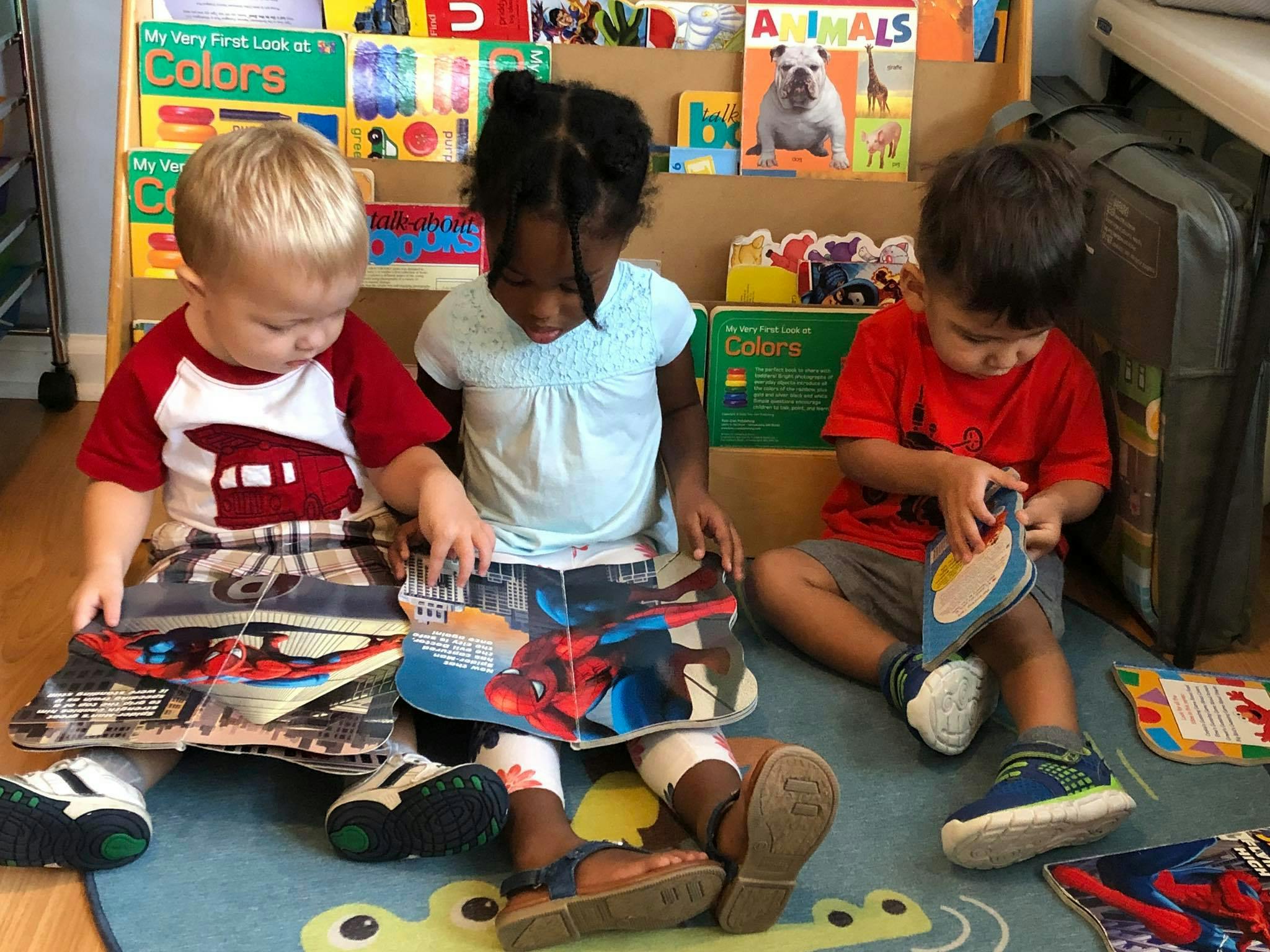 Three children sitting on the floor reading books