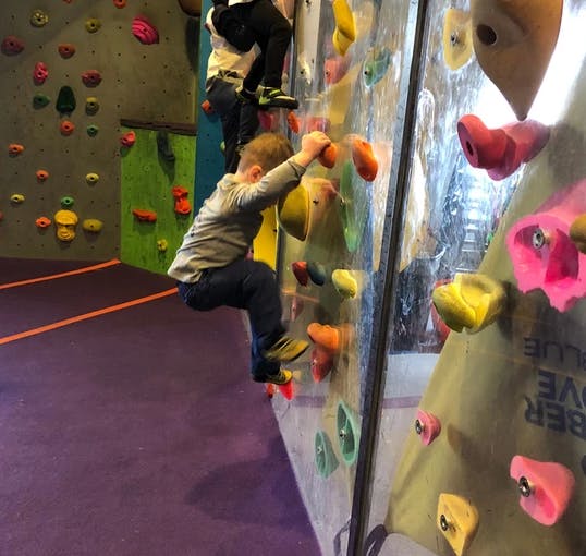 Child climbing an indoor rock wall