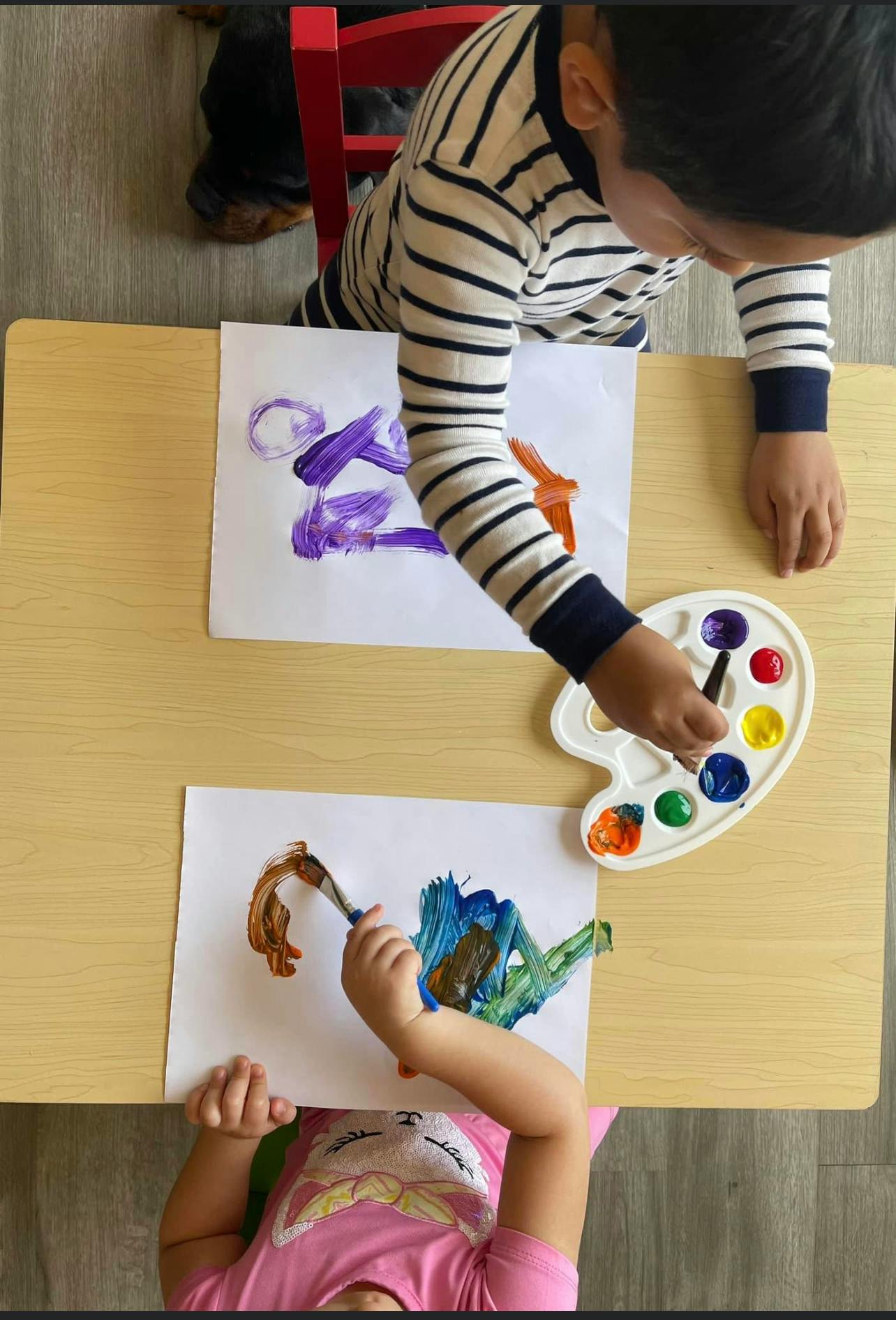 Two children painting at a table