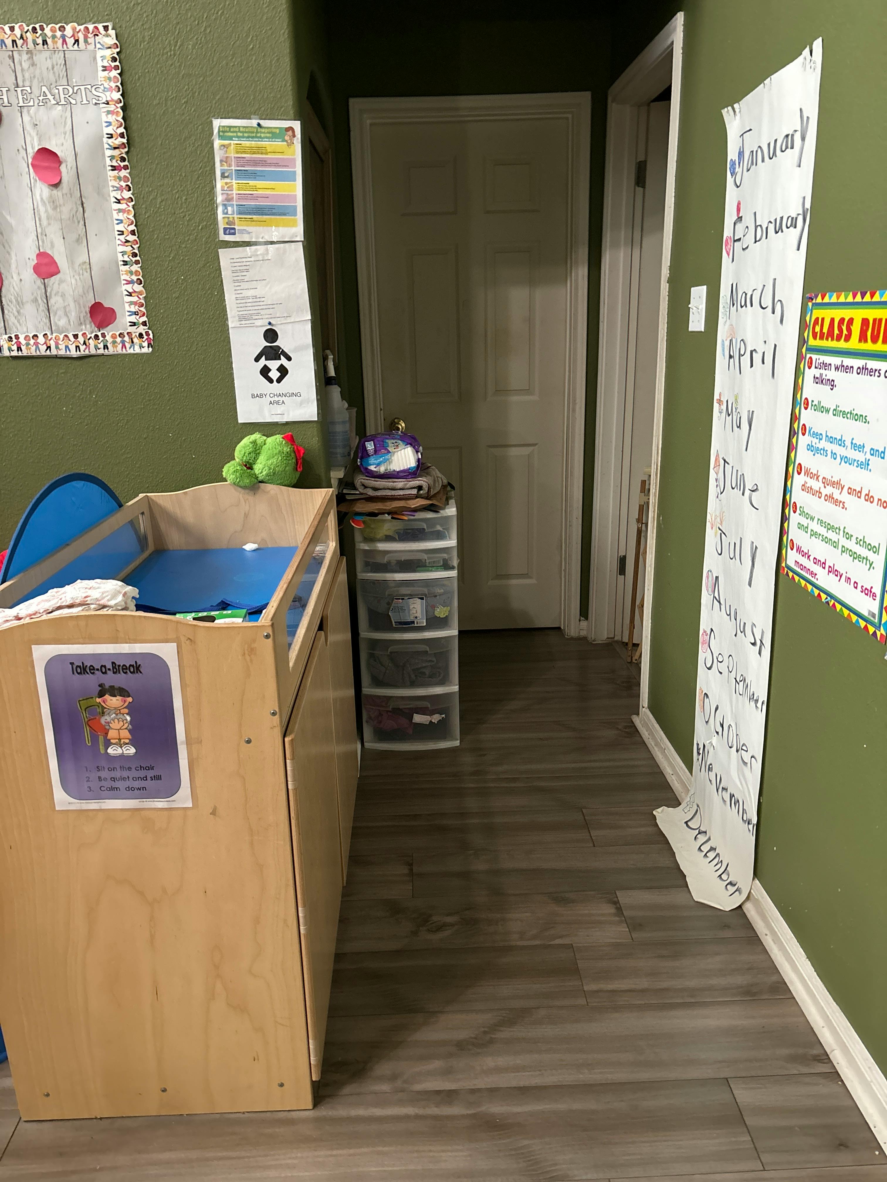 Changing table in a room with green walls and a door