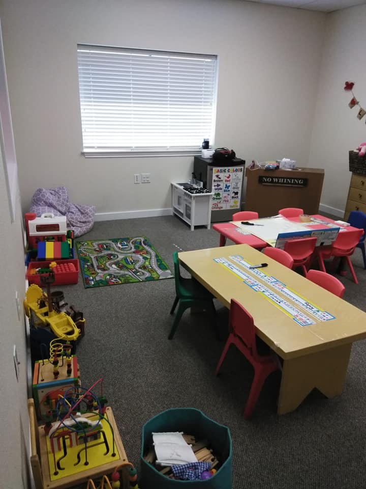 Playroom with tables, chairs, and toys