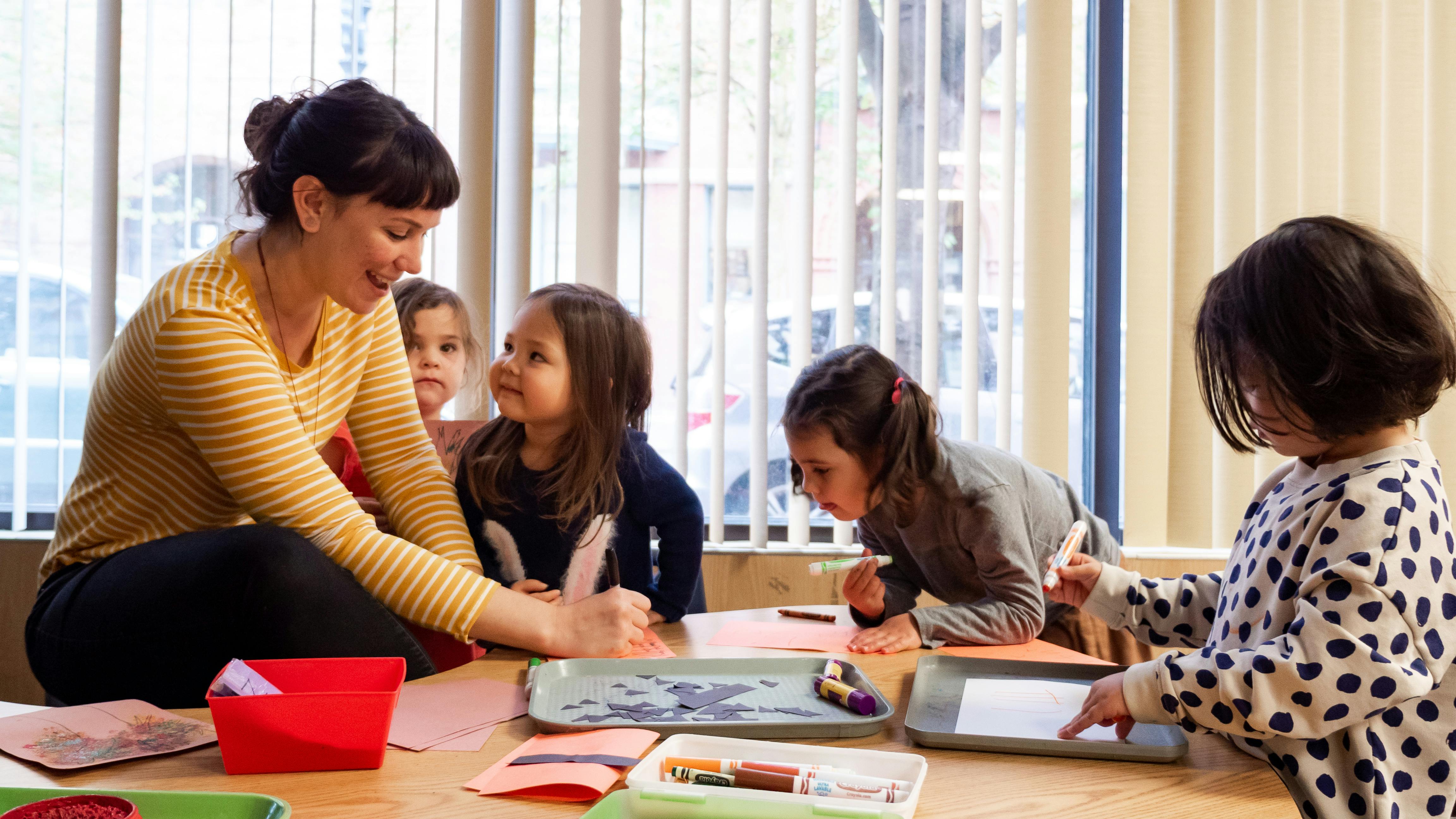 Adult and children at a table doing an activity