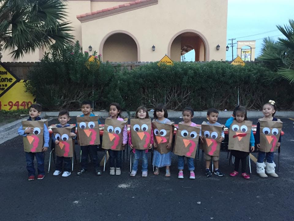 Group of children wearing turkey costumes made from paper bags