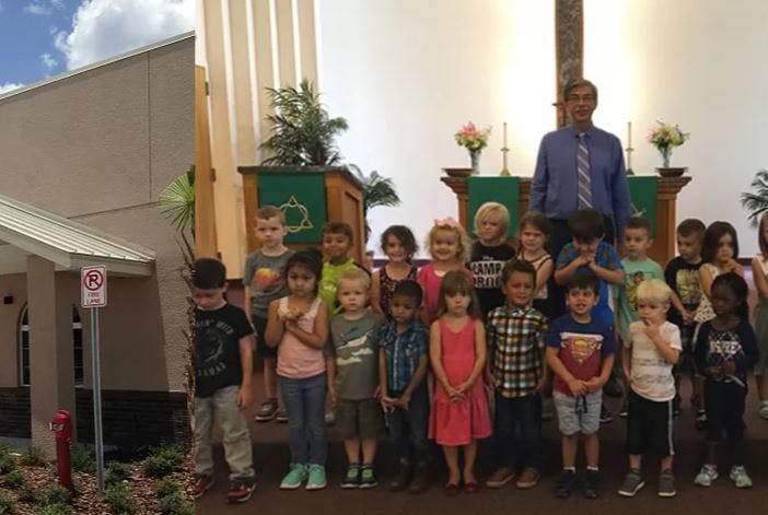 Adult and group of children standing in front of an altar