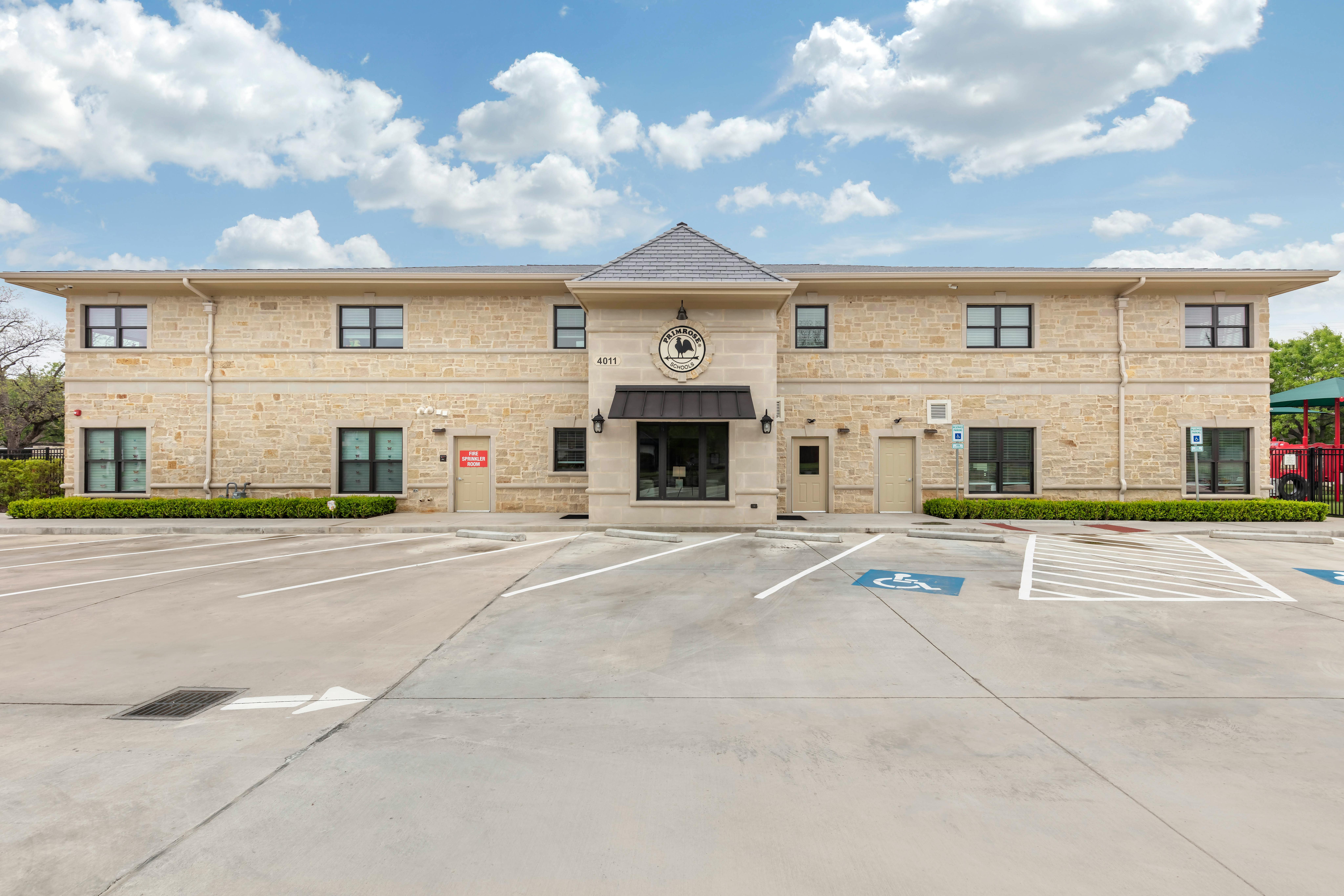 Exterior view of a Primrose Schools building with a parking lot in front