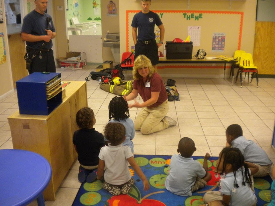 Adults interacting with children in a classroom setting