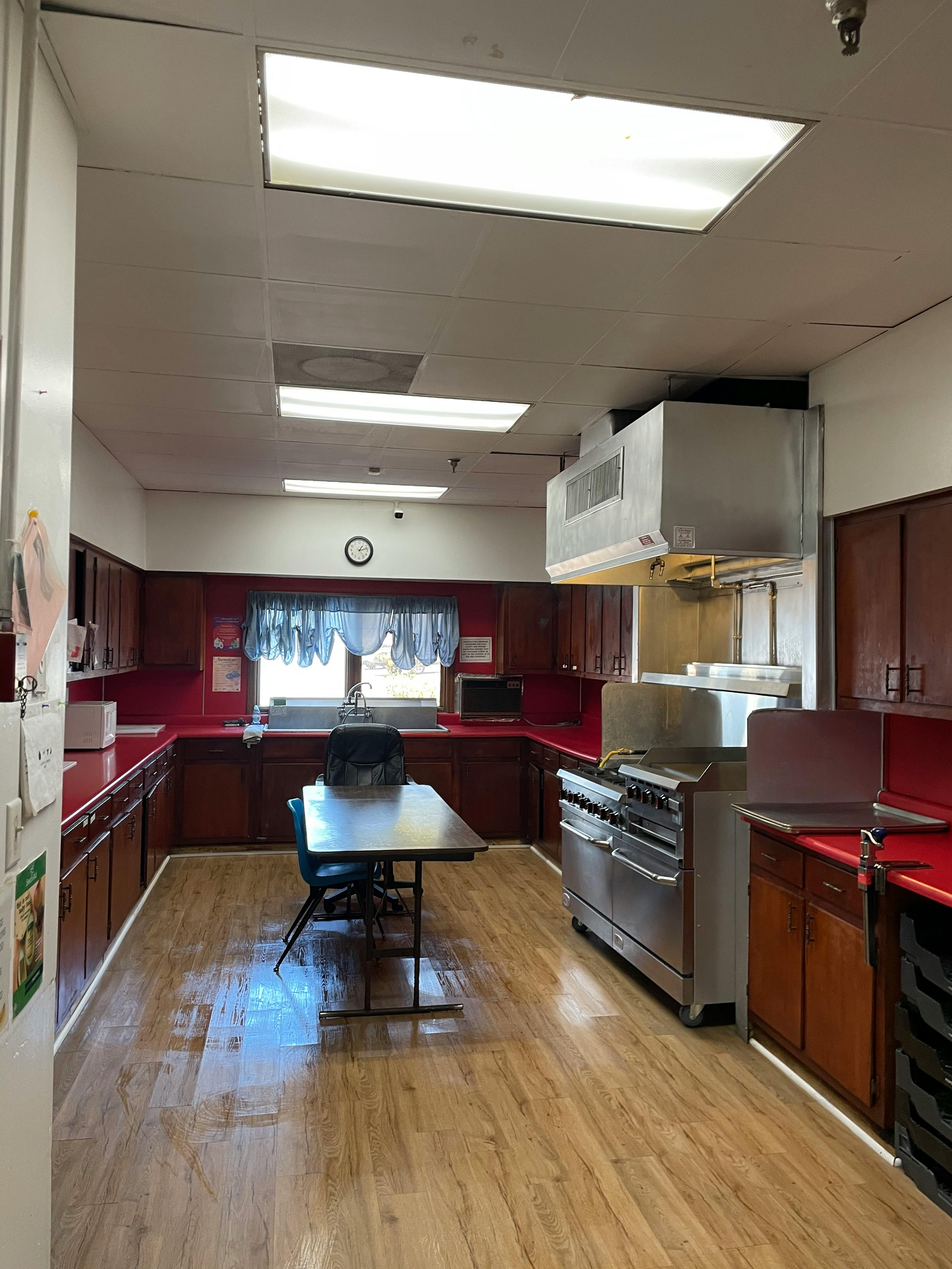 Kitchen with red countertops, wooden cabinets, and a large stove
