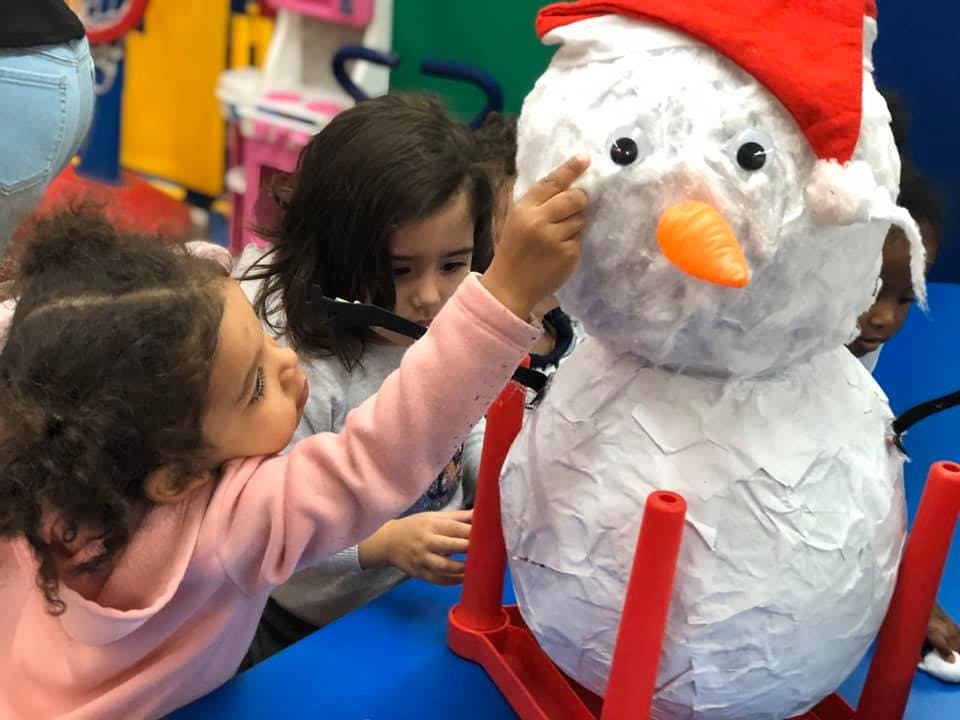 Child touching a snowman decoration