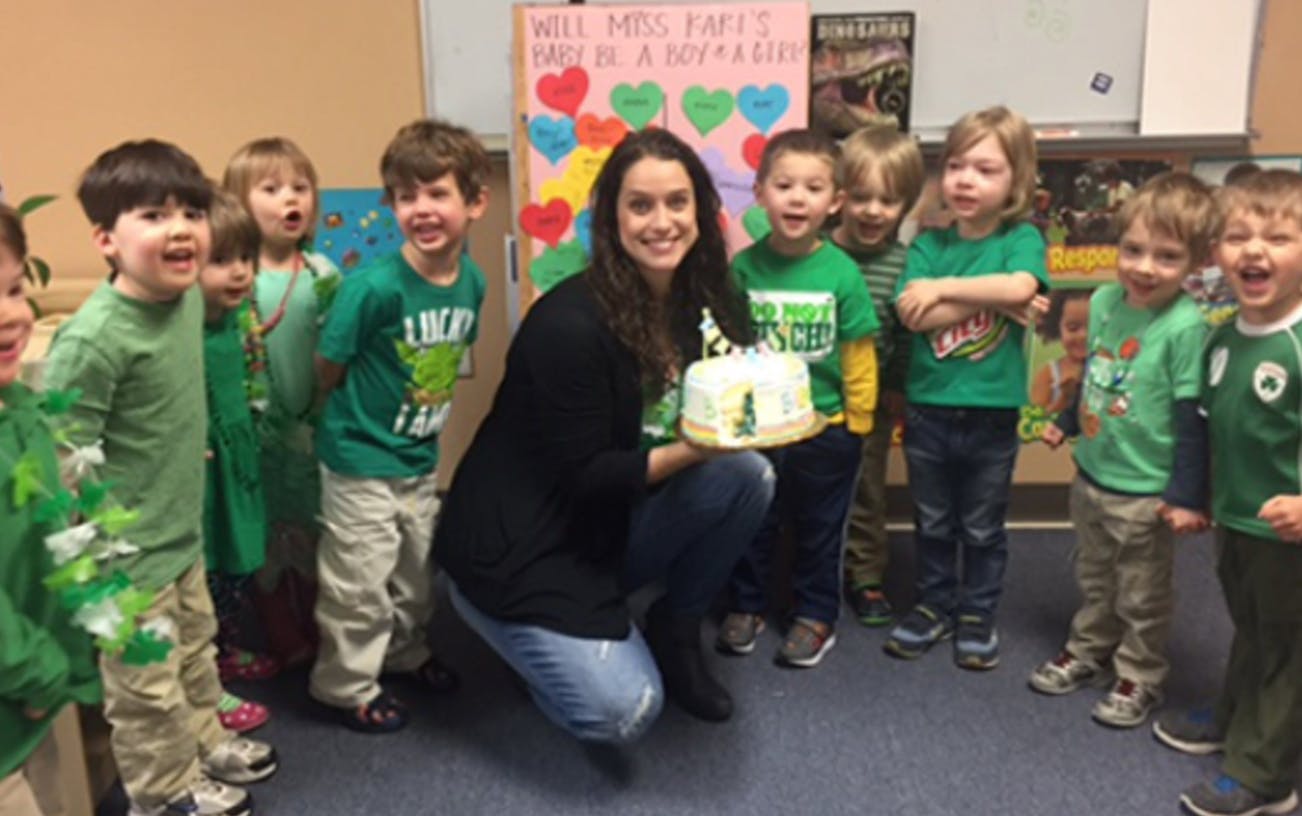 Person holding a cake surrounded by children